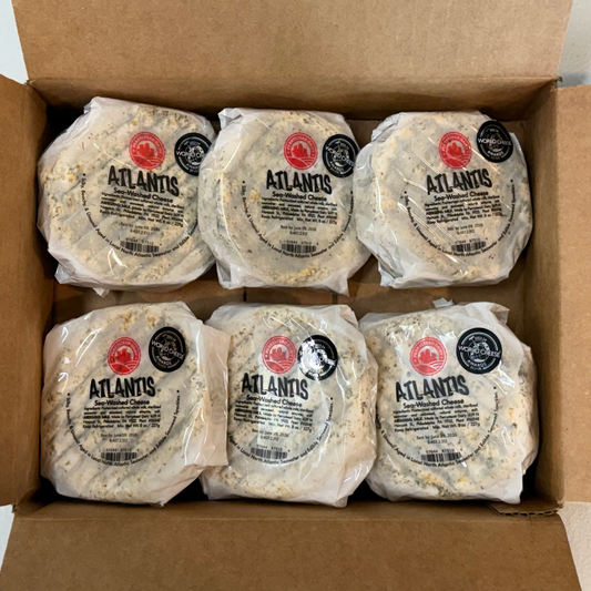 Box of Atlantis cheese wheels with clear packaging